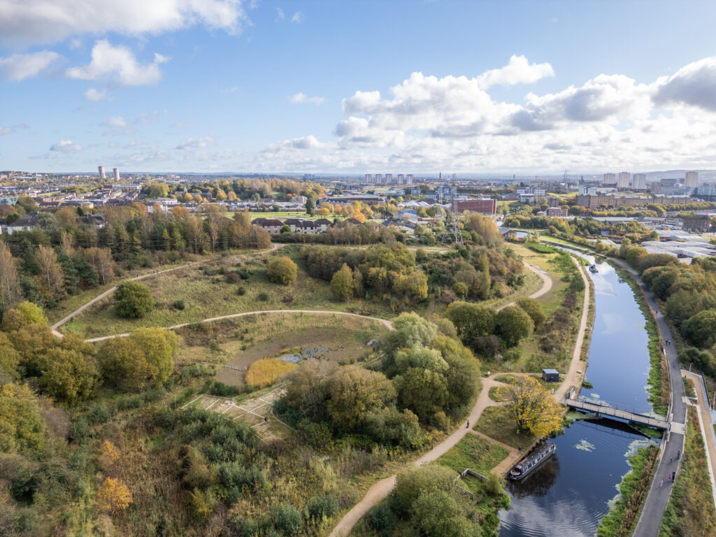 A drone shot of Hamiltonhill Claypits with the Glasgow skyline behind.